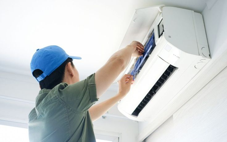 Property maintenance technician servicing an air conditioner